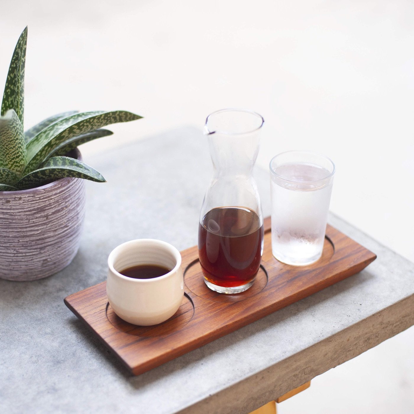 A coffee service tray with a carafe, cup, and glass of water at Sey Coffee